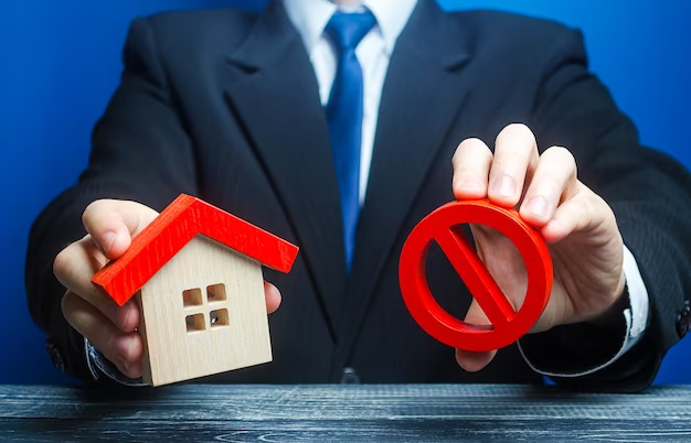 Man holding house and red prohibition symbol no