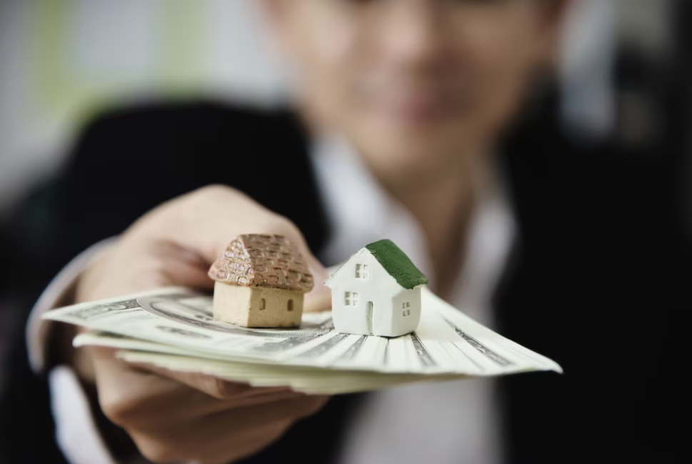 man in a classic suit hands out money with houses on it